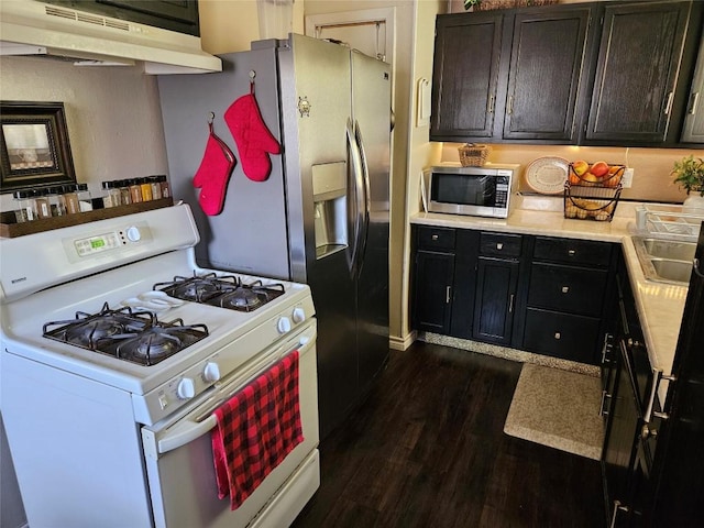 kitchen with dark wood finished floors, gas range gas stove, under cabinet range hood, stainless steel microwave, and light countertops