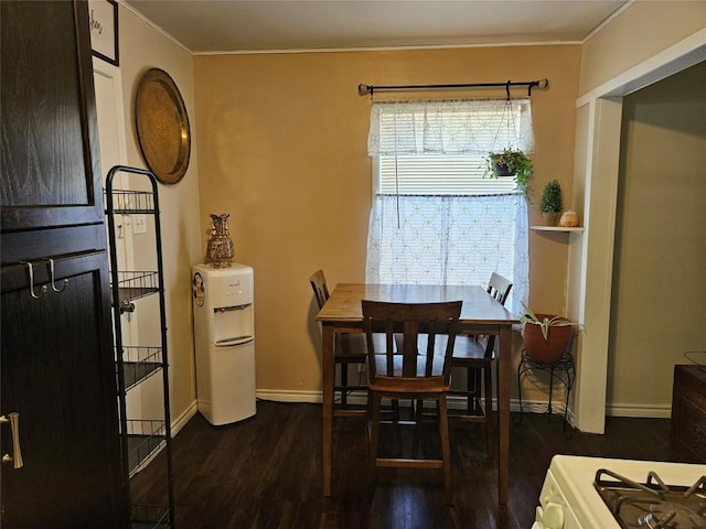 dining room featuring ornamental molding, baseboards, and wood finished floors