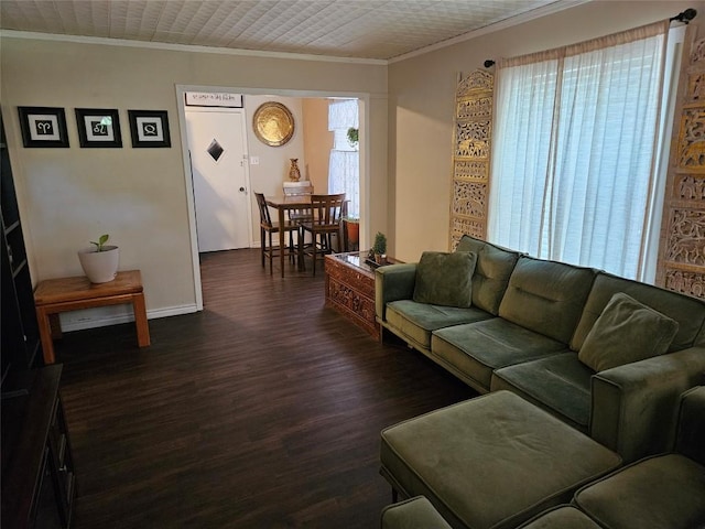 living room with baseboards, crown molding, and dark wood finished floors