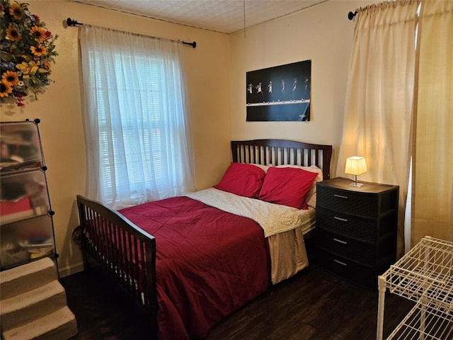 bedroom with dark wood-style flooring