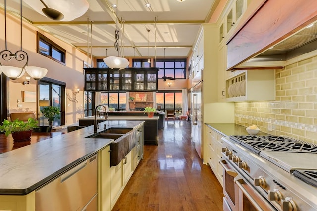 8700 Crest View Rd, Austin, TX 78737 - kitchen with stainless steel appliances, a large island, a towering ceiling, dark wood-style flooring, and decorative backsplash