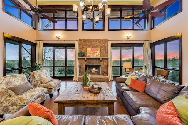 8700 Crest View Rd, Austin, TX 78737 - living area featuring ceiling fan, a high ceiling, wood finished floors, a stone fireplace, and healthy amount of natural light