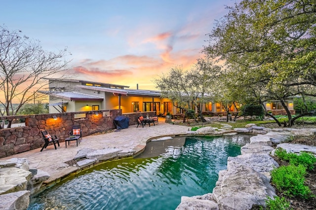 8700 Crest View Rd, Austin, TX 78737 - pool at dusk featuring a patio and an outdoor pool