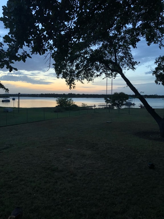 658 Golden Beach Dr, Buchanan Dam, TX 78609 - yard at dusk with a water view