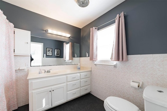 658 Golden Beach Dr, Buchanan Dam, TX 78609 - bathroom featuring toilet, vanity, a wainscoted wall, and tile walls