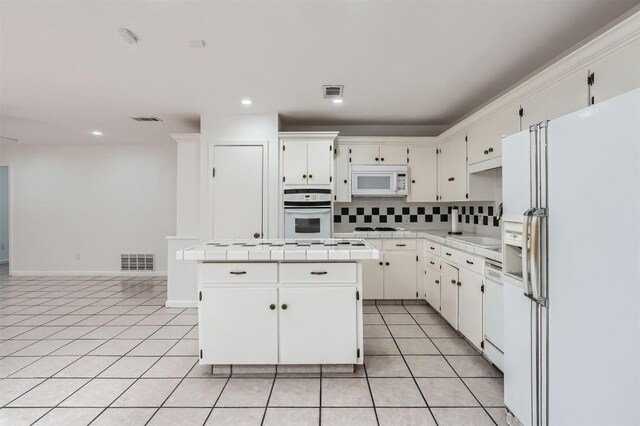 3108 Matador Dr, Austin, TX 78741 - kitchen with tile counters, visible vents, white appliances, and a center island