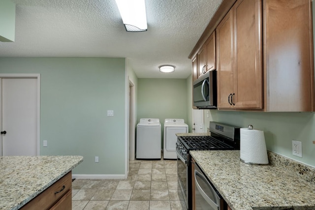 818 Kimbro St, Taylor, TX 76574 - kitchen with appliances with stainless steel finishes, separate washer and dryer, baseboards, a textured ceiling, and brown cabinetry