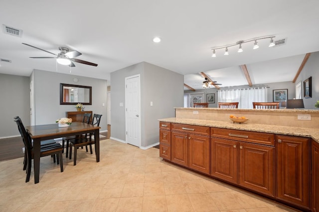 20807 Boggy Ford Rd, Lago Vista, TX 78645 - kitchen featuring ceiling fan, light stone counters, and brown cabinets