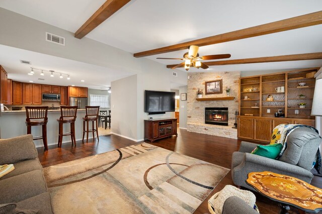 20807 Boggy Ford Rd, Lago Vista, TX 78645 - living room with dark wood-type flooring, a ceiling fan, a fireplace, and beam ceiling