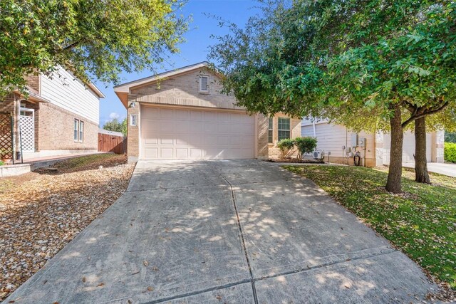 132 Grazing Horse Ln, Manchaca, TX 78652 - view of front facade featuring brick siding, driveway, fence, and an attached garage