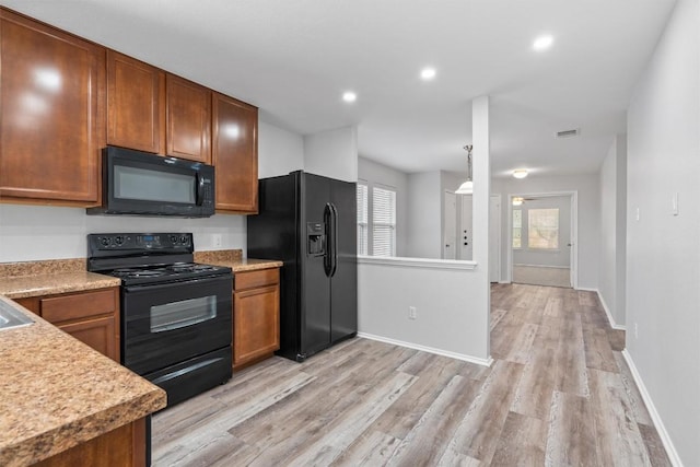 132 Grazing Horse Ln, Manchaca, TX 78652 - kitchen featuring light wood-style flooring, light countertops, black appliances, and visible vents