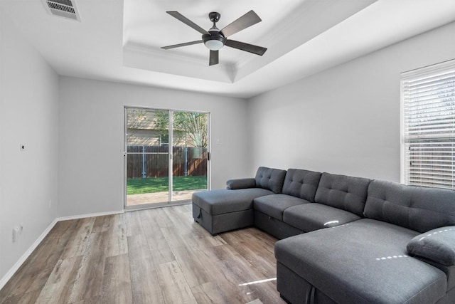 132 Grazing Horse Ln, Manchaca, TX 78652 - living area featuring a tray ceiling, wood finished floors, baseboards, visible vents, and ceiling fan