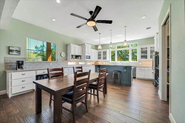 dining room with healthy amount of natural light, a ceiling fan, dark wood-style floors, baseboards, and recessed lighting