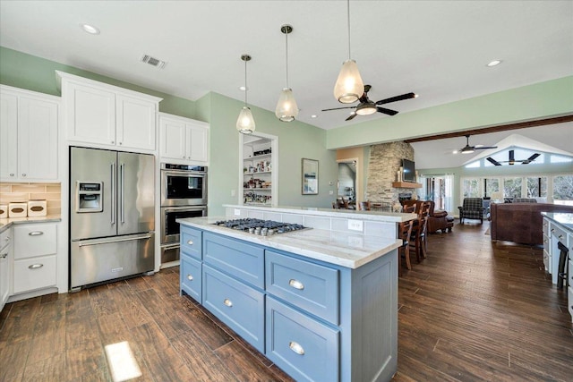 kitchen featuring stainless steel appliances, a ceiling fan, white cabinetry, open floor plan, and dark wood finished floors