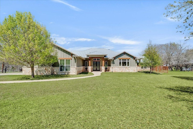 view of front of property featuring french doors, a front lawn, board and batten siding, and stone siding