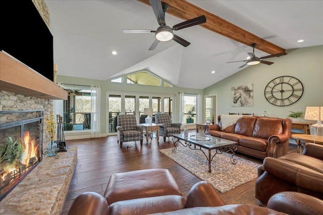 living area featuring ceiling fan, hardwood / wood-style flooring, beam ceiling, a fireplace, and recessed lighting
