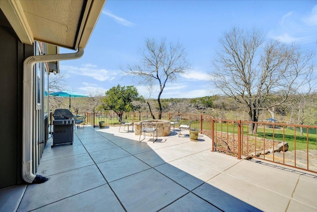 view of patio / terrace with an outdoor fire pit, a grill, and fence