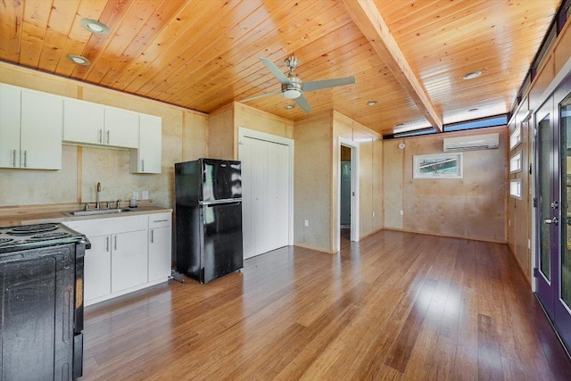100 E Lisa Dr, Austin, TX 78752 - kitchen with freestanding refrigerator, range, an AC wall unit, light wood-style floors, and a wooden ceiling with exposed beams