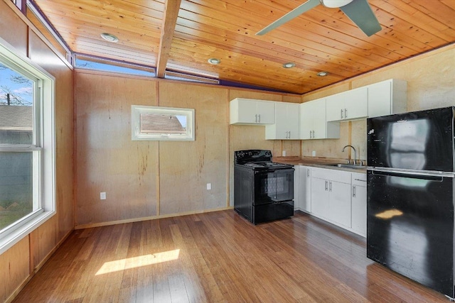 100 E Lisa Dr, Austin, TX 78752 - kitchen featuring black appliances, wood ceiling, hardwood / wood-style floors, white cabinets, and plenty of natural light