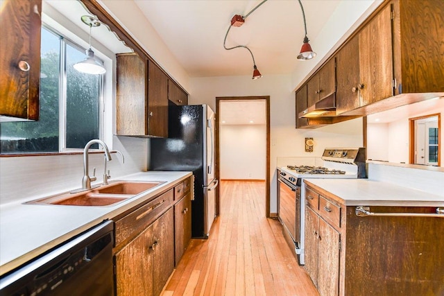 100 E Lisa Dr, Austin, TX 78752 - kitchen with gas range oven, black dishwasher, light wood-type flooring, and light countertops