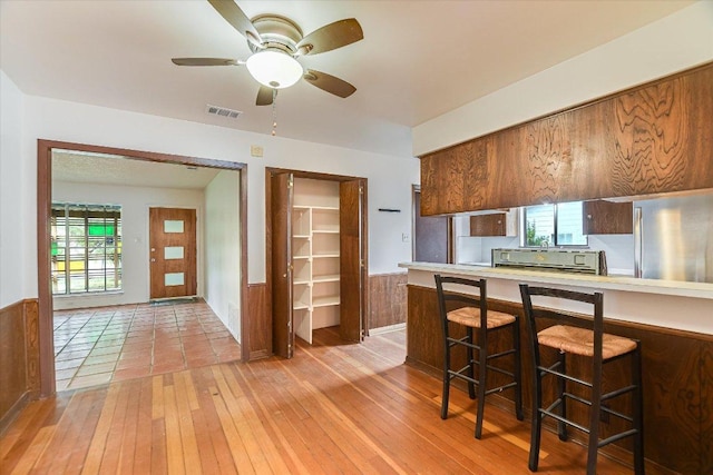 100 E Lisa Dr, Austin, TX 78752 - kitchen with freestanding refrigerator, light wood-style flooring, ceiling fan, and light countertops