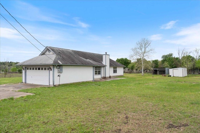 182 Lake Front Dr, Cedar Creek, TX 78612 - view of grassy yard featuring concrete driveway, an attached garage, and a storage unit