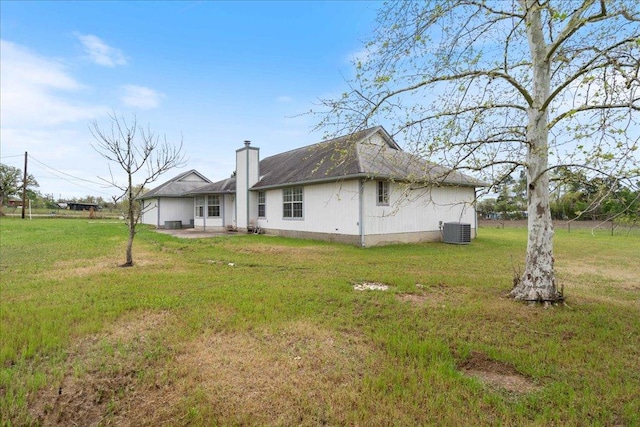 182 Lake Front Dr, Cedar Creek, TX 78612 - rear view of house featuring a chimney, a lawn, and a patio area