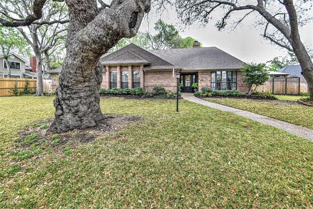 2921 Olympia Dr, Temple, TX 76502 - ranch-style home with fence, a front lawn, brick siding, a shingled roof, and a chimney