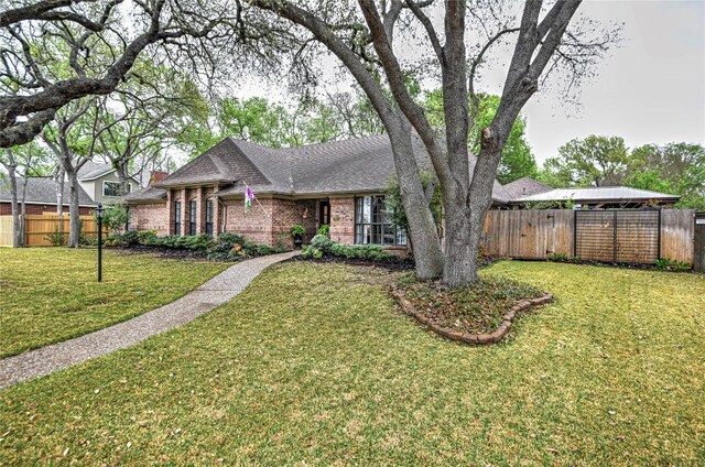 2921 Olympia Dr, Temple, TX 76502 - view of front of house with brick siding, fence, a front lawn, and a shingled roof