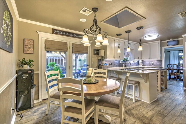 2921 Olympia Dr, Temple, TX 76502 - dining room featuring an inviting chandelier, wood finished floors, ornamental molding, and visible vents
