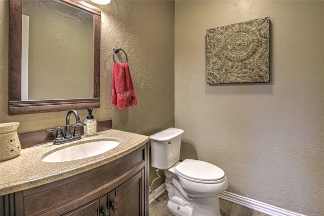 2921 Olympia Dr, Temple, TX 76502 - half bath featuring baseboards, toilet, wood finished floors, vanity, and a textured wall