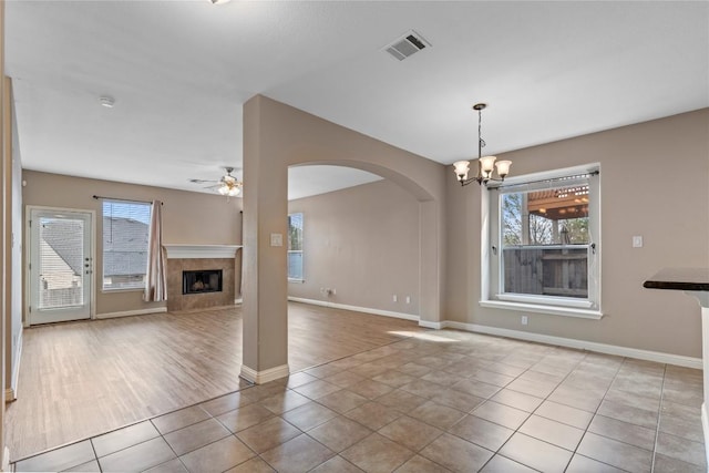 1628 Hidden Springs Path, Round Rock, TX 78665 - unfurnished living room featuring tile patterned floors, a chandelier, plenty of natural light, and a ceiling fan