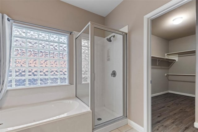 1628 Hidden Springs Path, Round Rock, TX 78665 - full bath featuring a shower stall, a bath, a walk in closet, baseboards, and wood finished floors