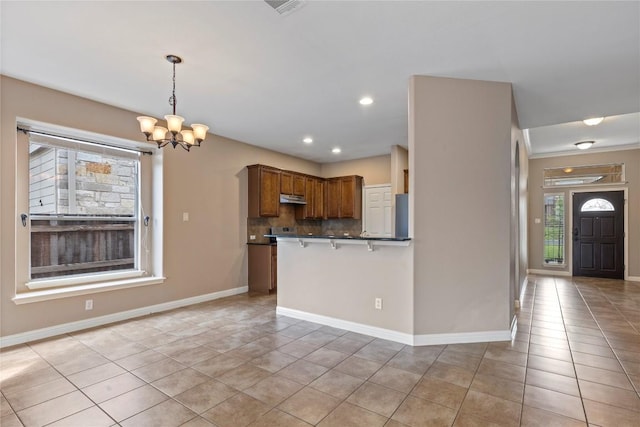 1628 Hidden Springs Path, Round Rock, TX 78665 - kitchen featuring under cabinet range hood, a chandelier, light tile patterned floors, dark countertops, and recessed lighting