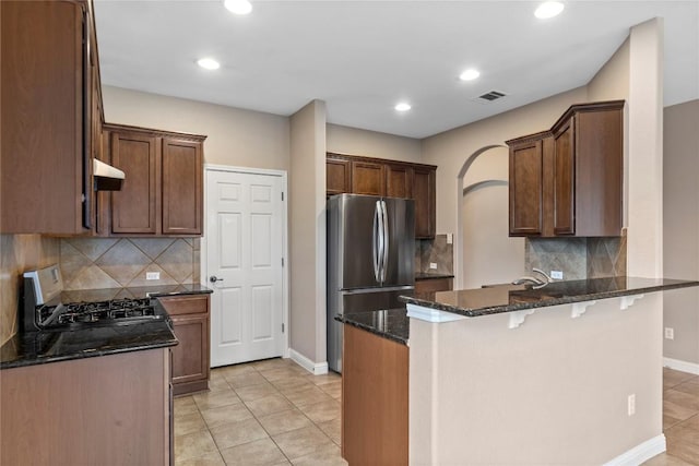 1628 Hidden Springs Path, Round Rock, TX 78665 - kitchen featuring appliances with stainless steel finishes, a peninsula, dark stone countertops, baseboards, and recessed lighting