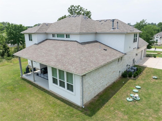 121 Black Talon Ln, Cedar Creek, TX 78612 - back of property featuring a patio area, a shingled roof, a lawn, and a garage