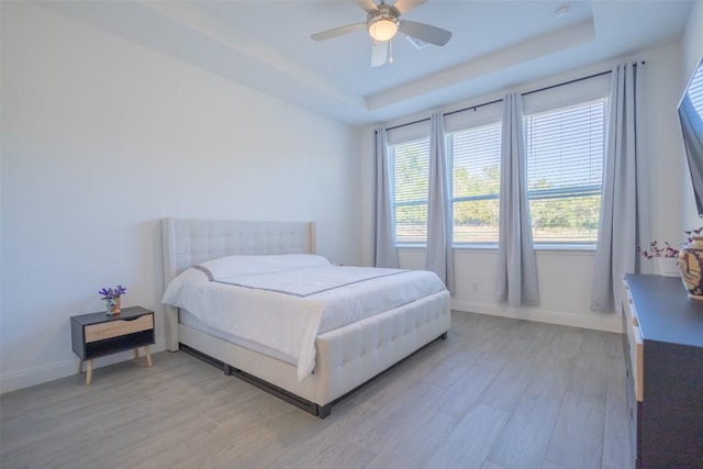 121 Black Talon Ln, Cedar Creek, TX 78612 - bedroom with light wood-style flooring, a raised ceiling, baseboards, and ceiling fan