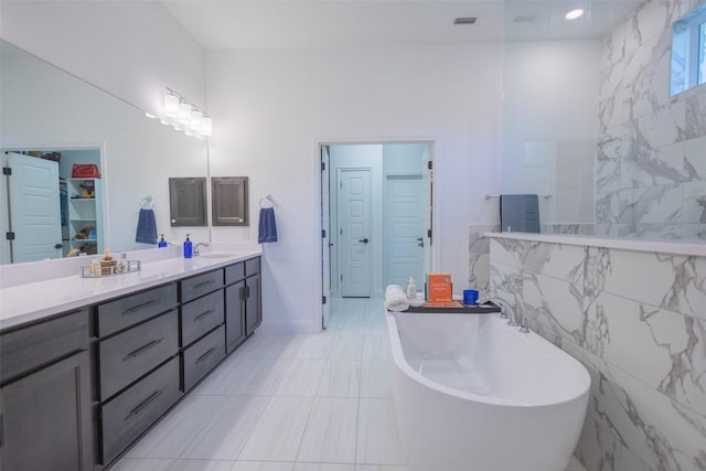 121 Black Talon Ln, Cedar Creek, TX 78612 - full bath with a soaking tub, vanity, tile walls, and a closet