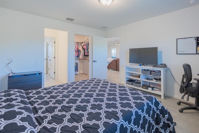 121 Black Talon Ln, Cedar Creek, TX 78612 - bedroom with wood finished floors, a walk in closet, and baseboards