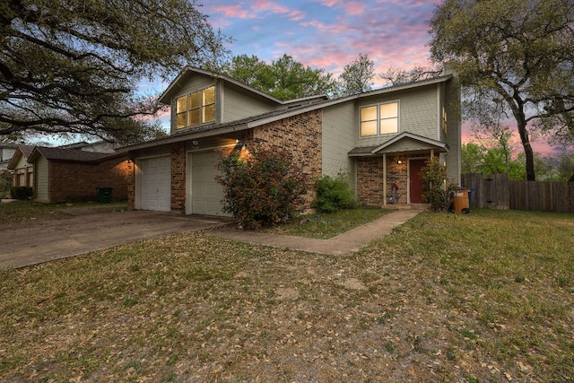 view of front of house featuring concrete driveway, fence, brick siding, a lawn, and a garage