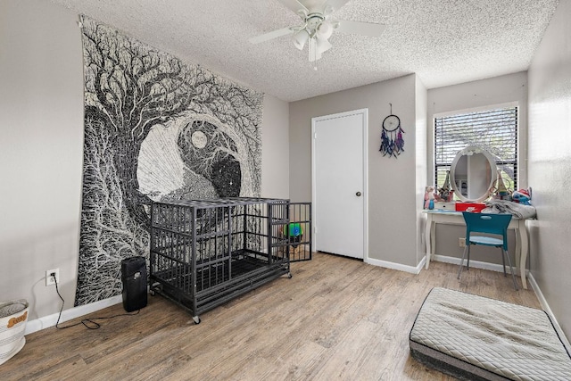living area featuring baseboards, wood finished floors, and ceiling fan