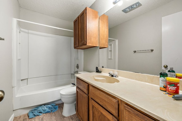 full bath featuring toilet, vanity, shower / bathing tub combination, wood finished floors, and a textured ceiling
