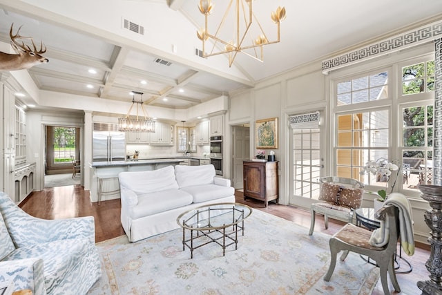 807 Terrace Mountain Dr, West Lake Hills, TX 78746 - living room featuring a notable chandelier, beam ceiling, wood finished floors, visible vents, and ornamental molding
