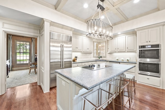 807 Terrace Mountain Dr, West Lake Hills, TX 78746 - kitchen featuring stainless steel appliances, a chandelier, coffered ceiling, wood finished floors, and a kitchen island