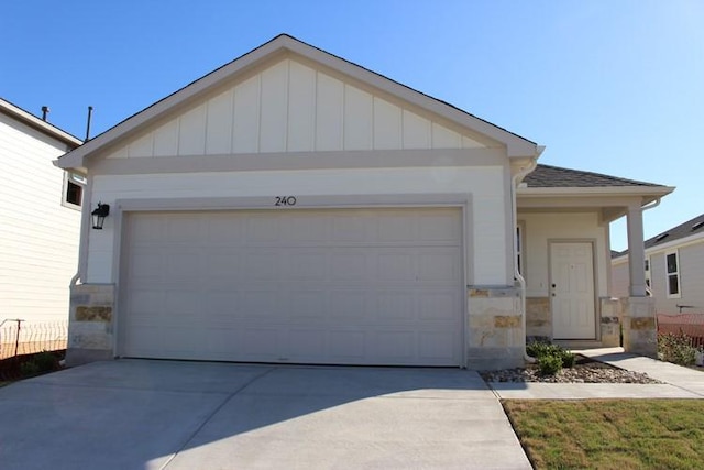 240 Hidalgo Ln, Elgin, TX 78621 - view of front of property featuring stone siding, concrete driveway, a garage, and board and batten siding