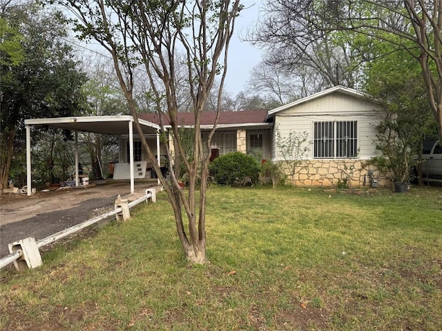 6300 Hickman Ave, Austin, TX 78723 - view of front of house with stone siding, driveway, a front lawn, and a carport
