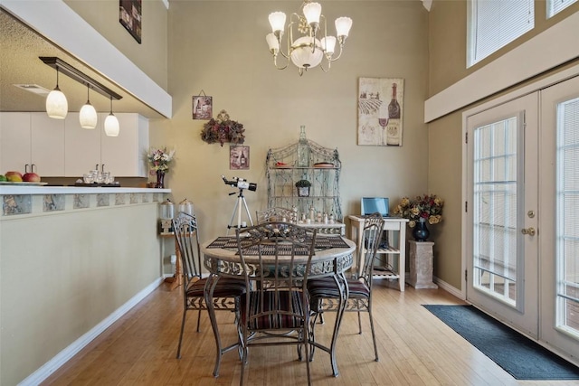 317 Venture Blvd S, Point Venture, TX 78645 - dining area featuring french doors, wood-type flooring, a chandelier, and a towering ceiling