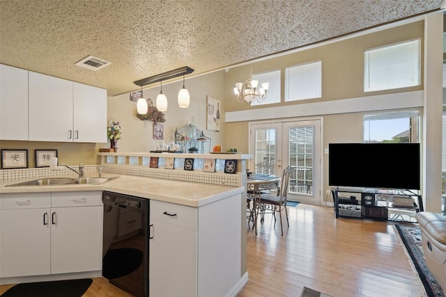 317 Venture Blvd S, Point Venture, TX 78645 - kitchen with dishwasher, a sink, a peninsula, a chandelier, and healthy amount of natural light