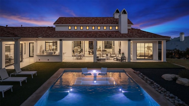 rear view of house featuring a hot tub, a patio, an outdoor hangout area, an outdoor pool, and stucco siding