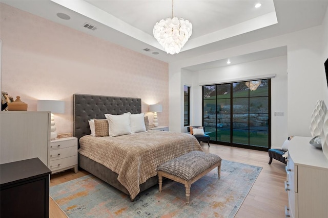 bedroom with access to exterior, light wood-type flooring, visible vents, recessed lighting, and a chandelier